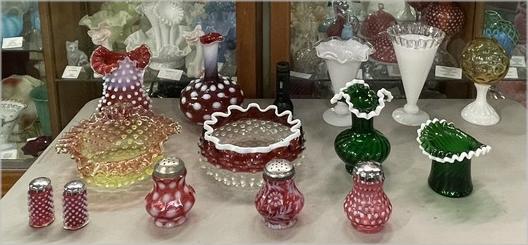 Colorful Fenton glass pieces arranged for display